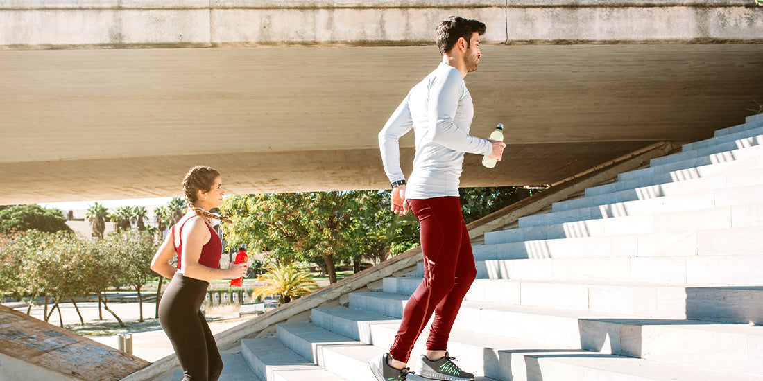 There's a guy and a girl doing some resistance training on the stairs.